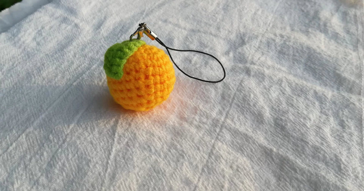 Virkad mandarin-nyckelring med grönt blad