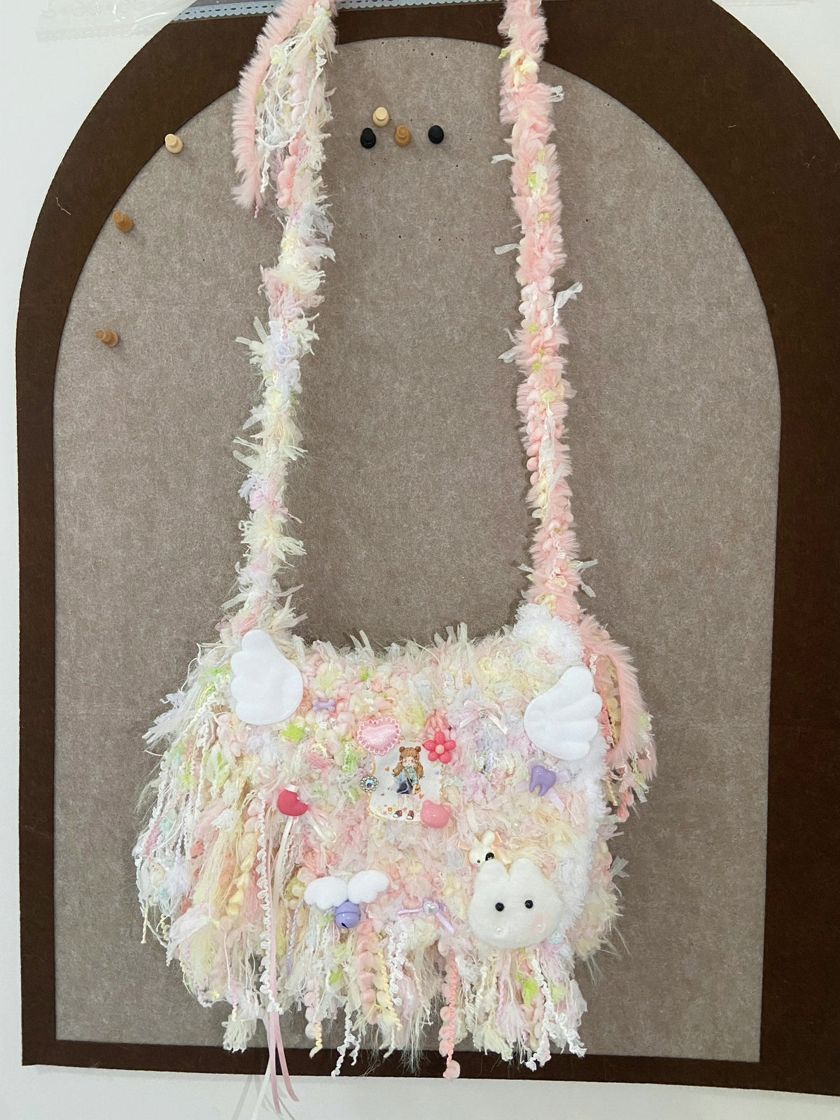 Pastellige Schultertasche aus Mix-Garn mit Anhängern