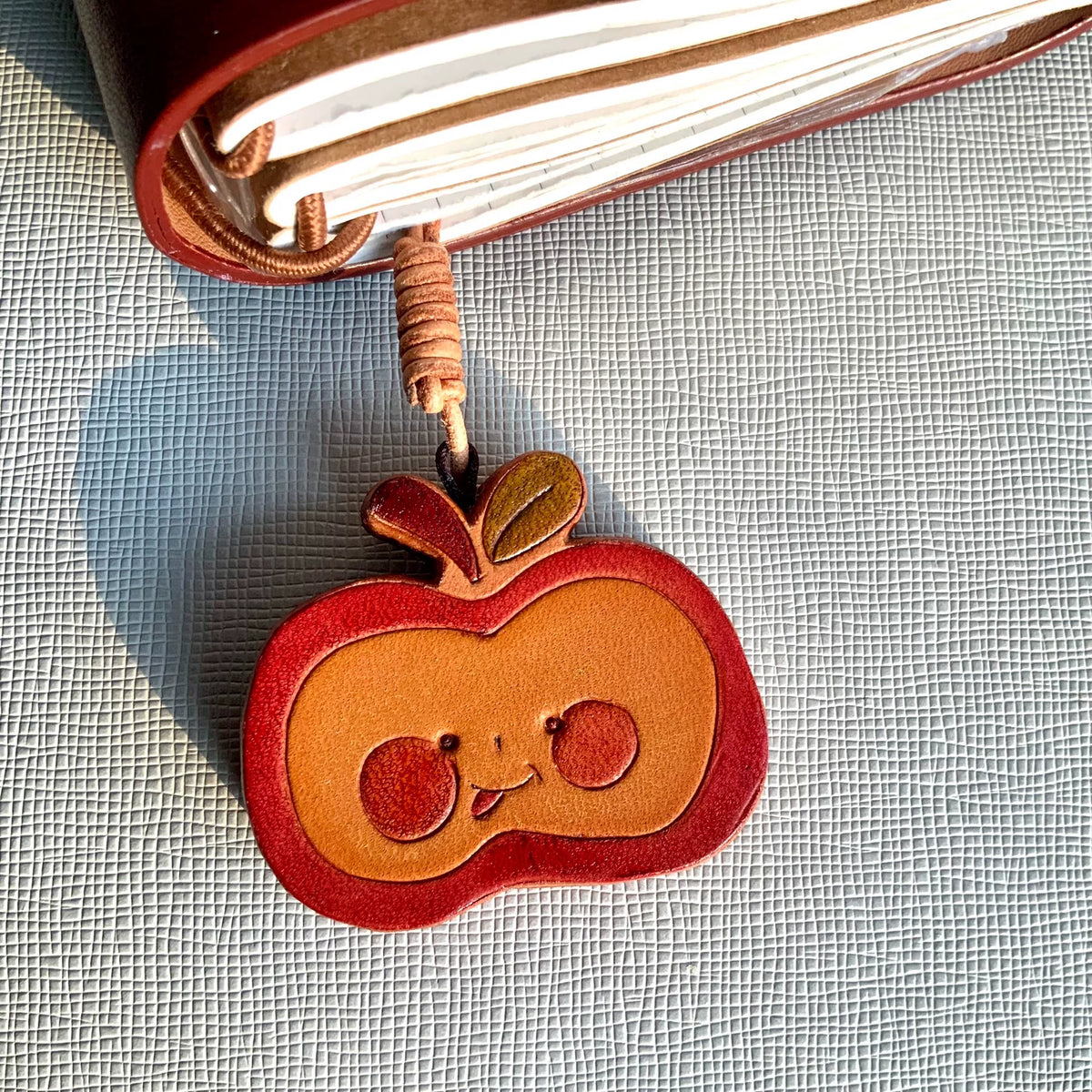 Handgesneden leren charms met zon en appel