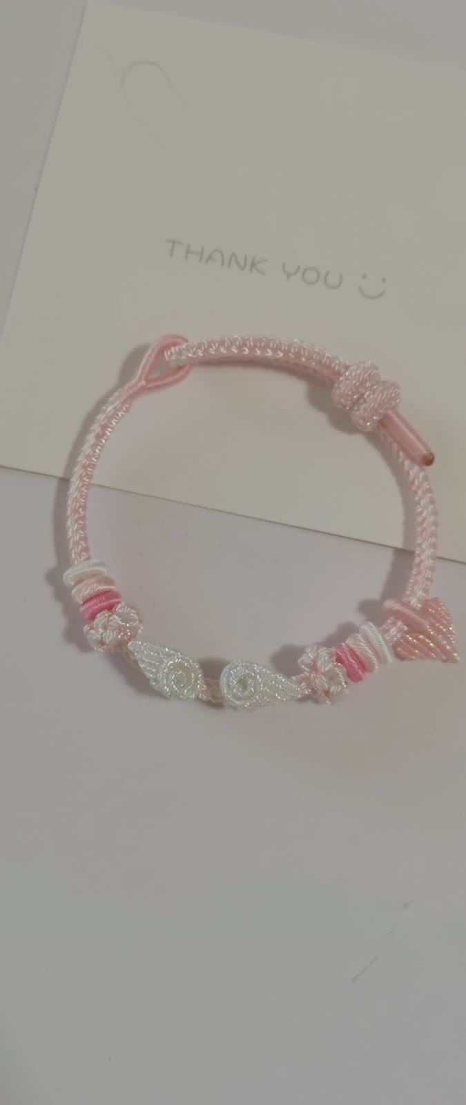Handvävt armband i rosa och vitt med blomma och rosett