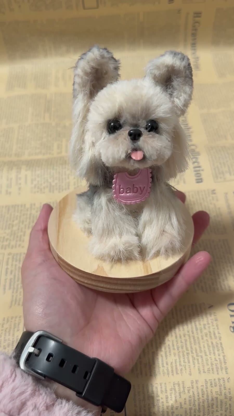 Figura de perro de peluche sobre base de madera