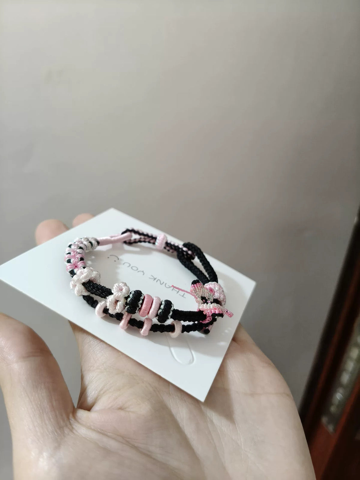 Handvävt armband i snöre med svart och rosa gradient