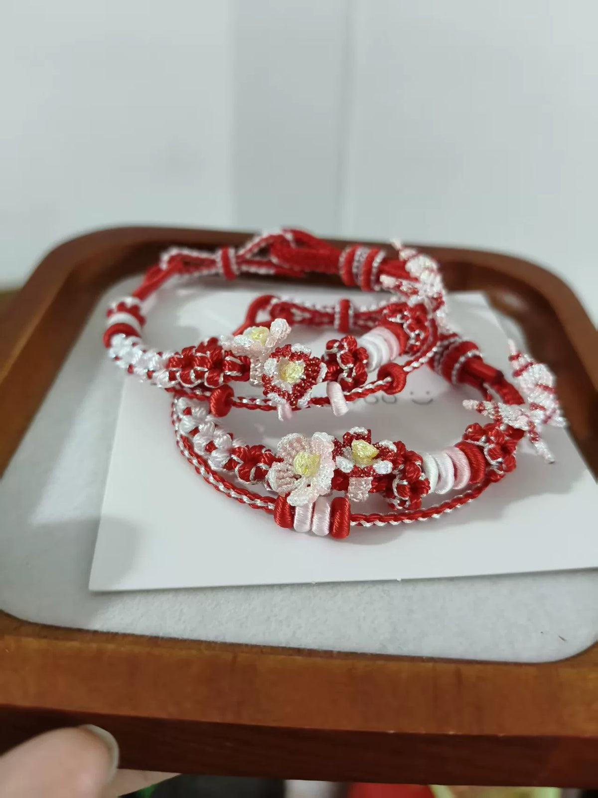 Handgegewobtes rot-weißes Armband mit Blumen