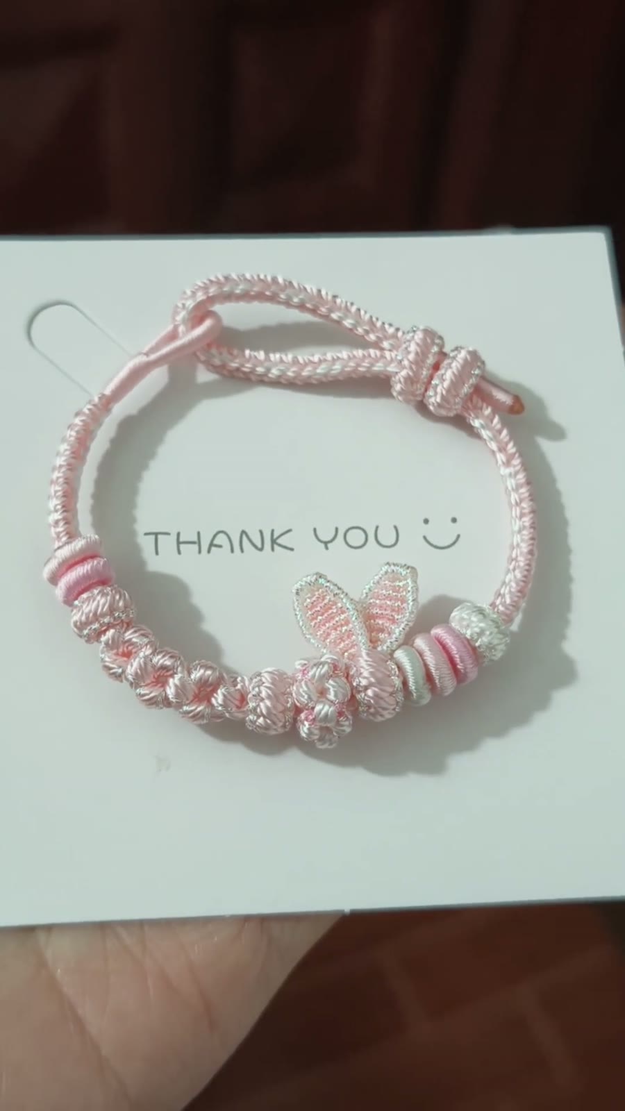 Handgema roze gevlochten armband met konijnenostjes