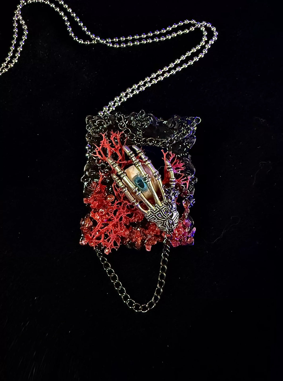Skeletal Hand Eye Pendant with Orange Moss