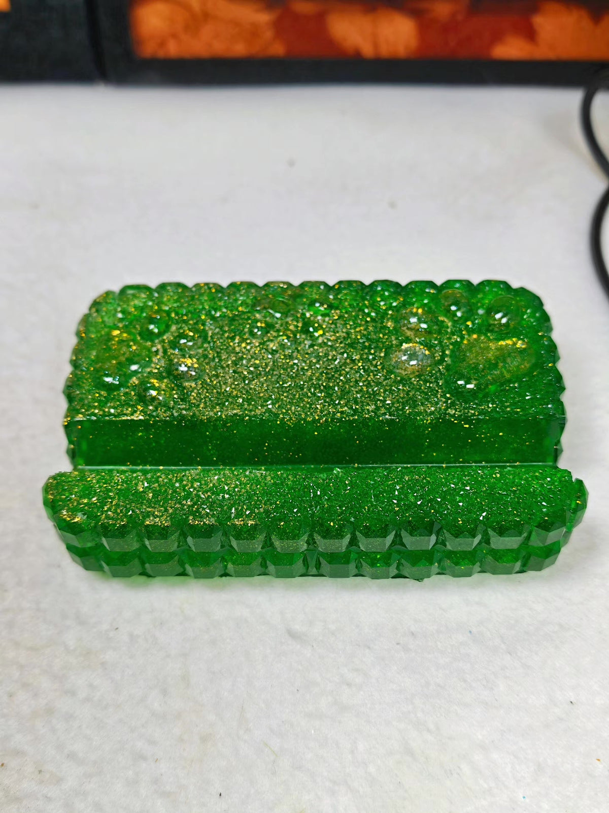 Soporte para móvil de resina verde con purpurina