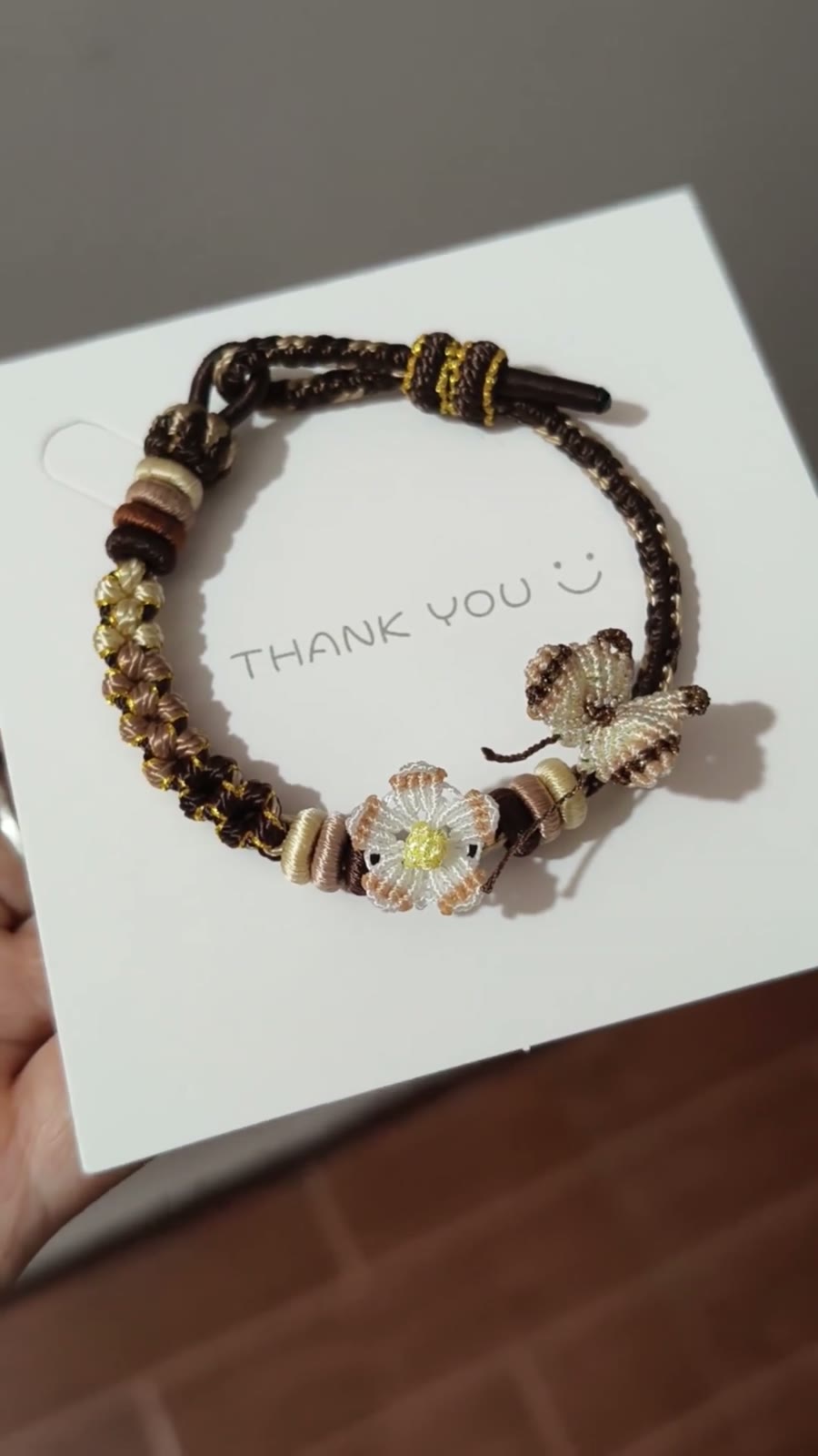 Handflätat armband i snöre svart guld blomma