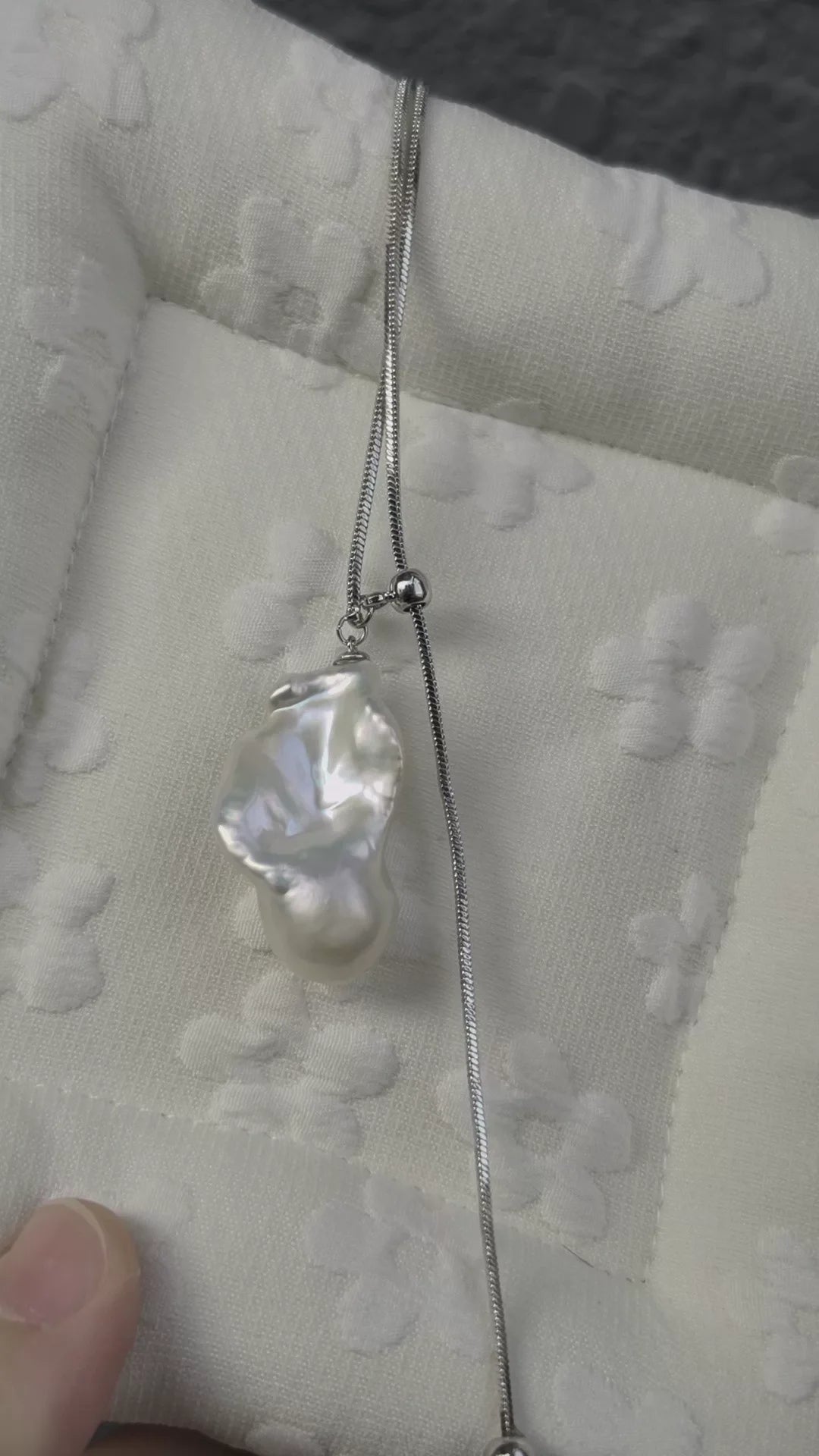 Large irregular white pearl on a fine silver-toned chain with slider bead