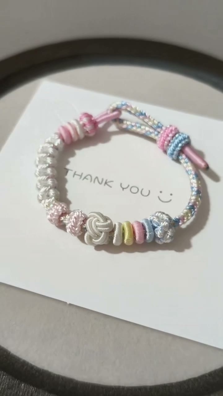 Pulseira de Cordão Tecida à Mão com Gradiente Pastel e Nós em Flor