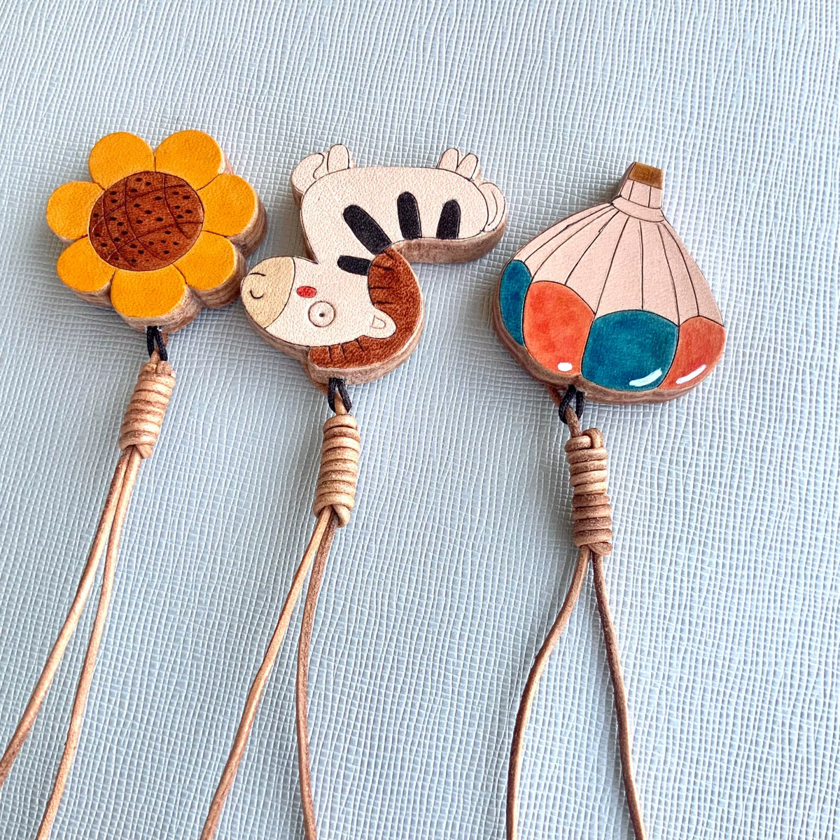 Set de charms de cuero: globo aerostático, cebra y girasol