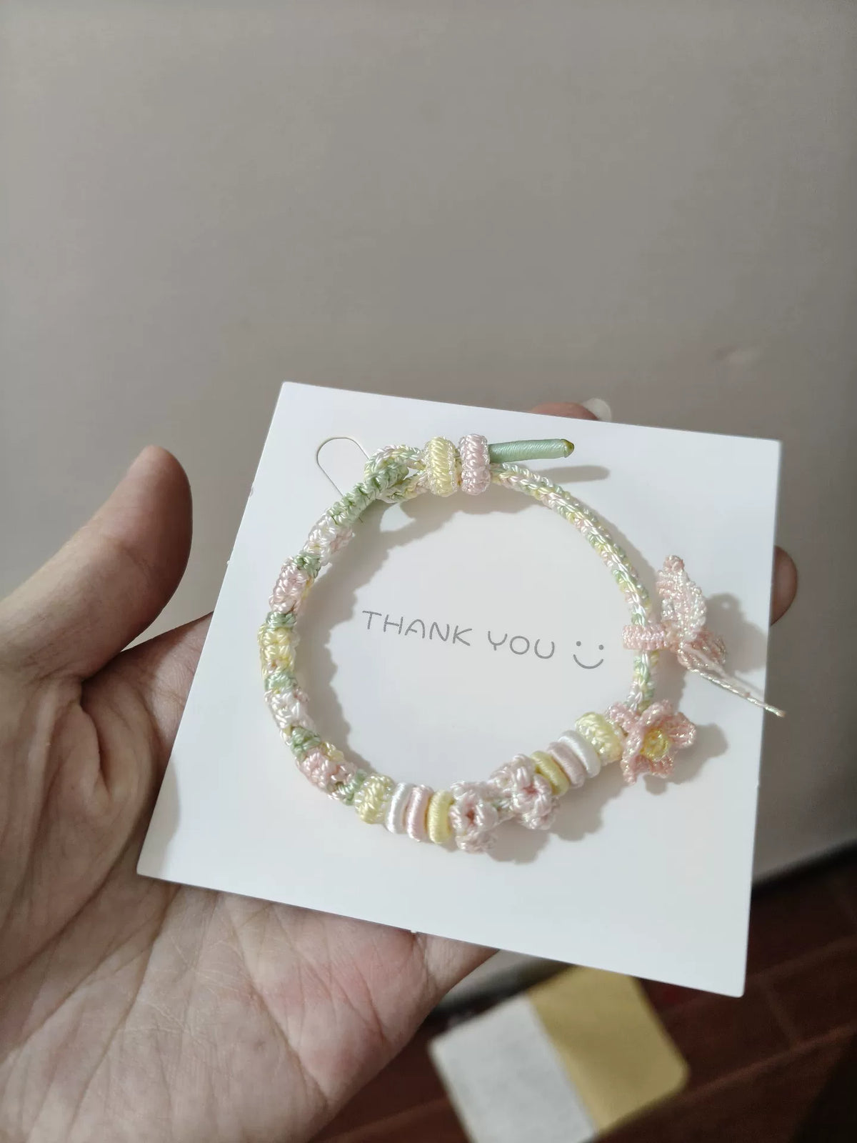 Bracelet en cordon tressé fleurs pastel et papillon