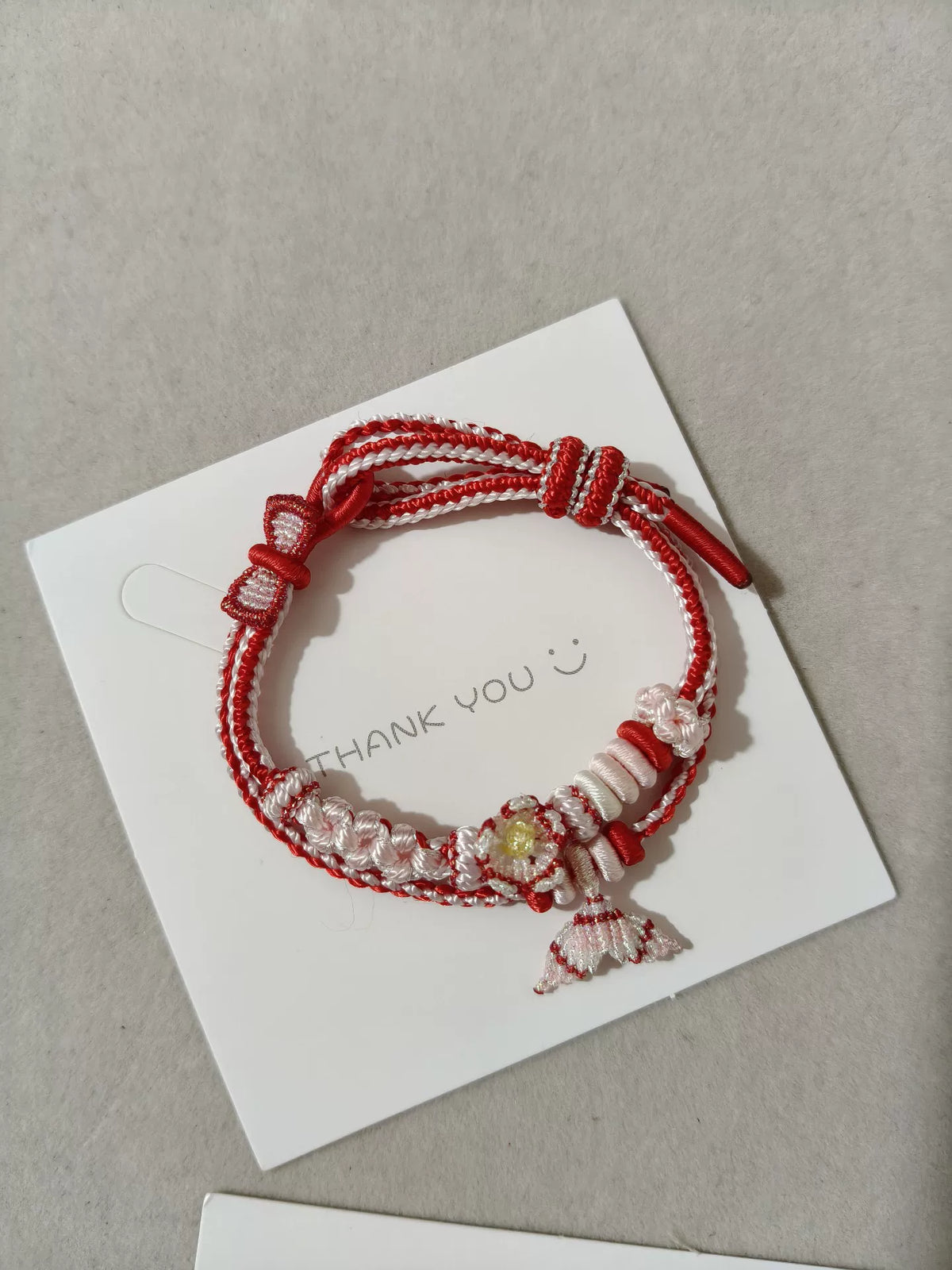 Pulsera tejida a mano con flor roja y blanca