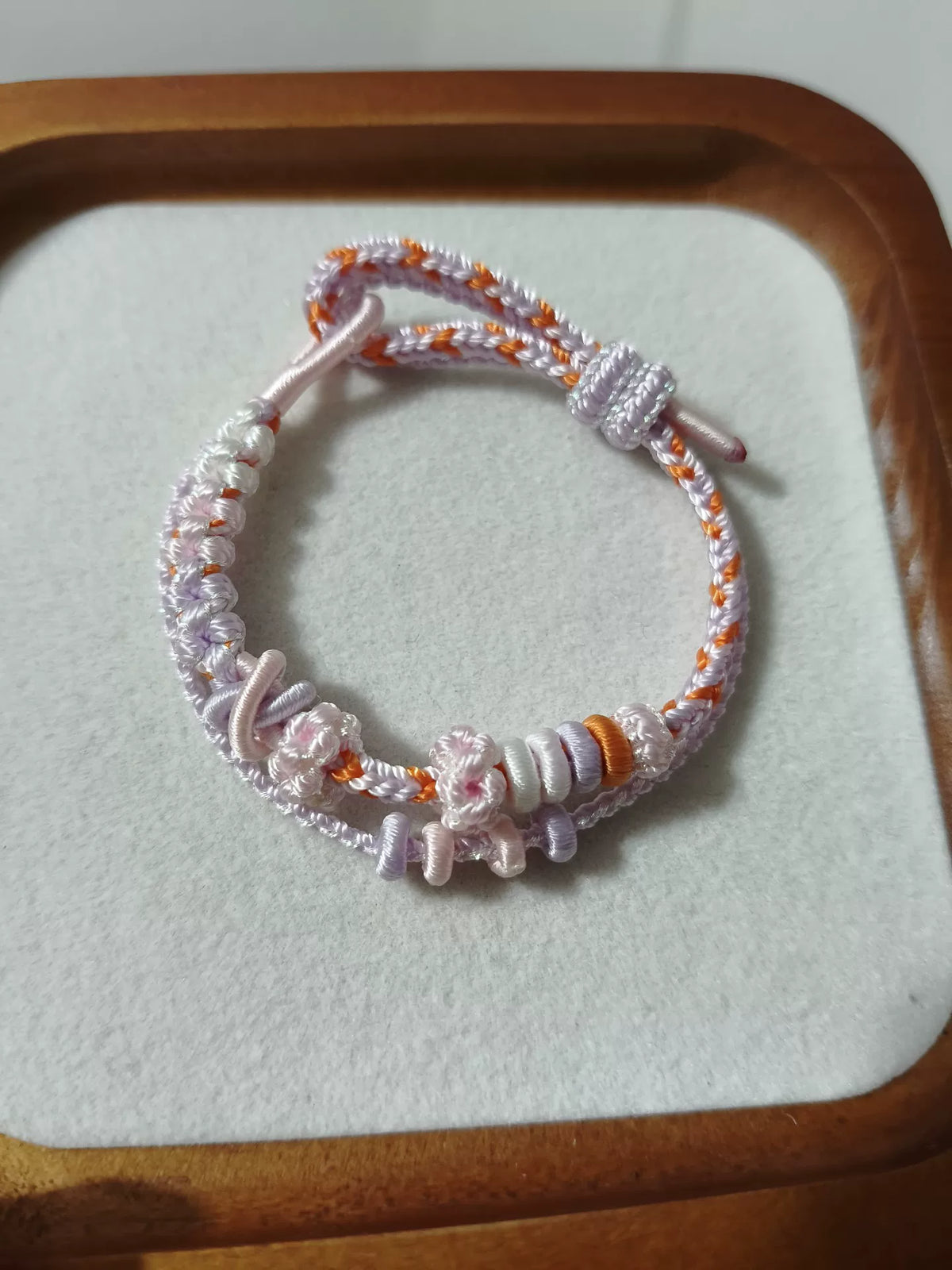 Handvävt armband i snöre vit och orange blomma