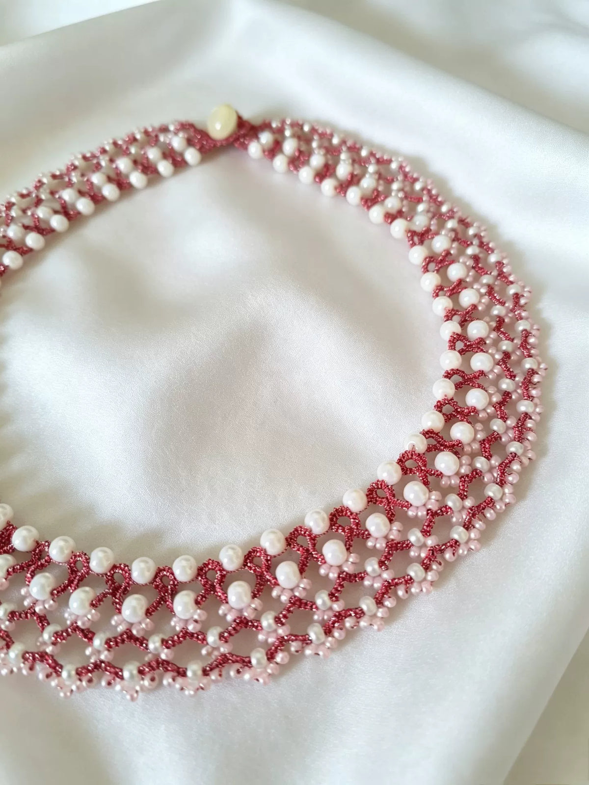 Rosa flätat spets- och pärlhalsband
