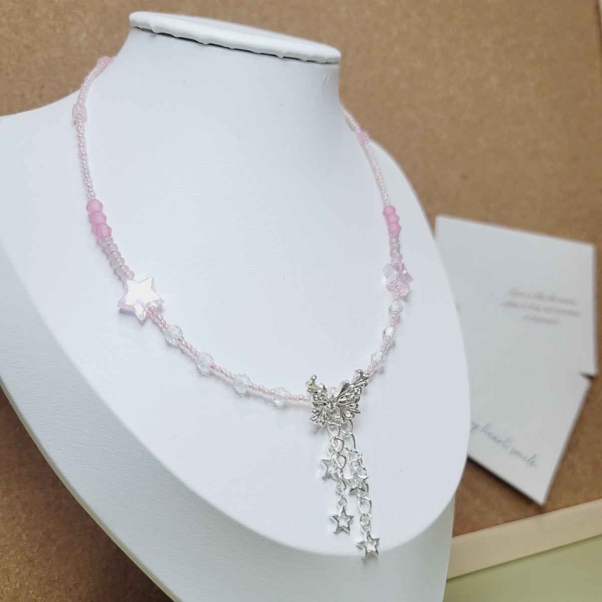 Rosa pärlhalsband med fjärilshänge
