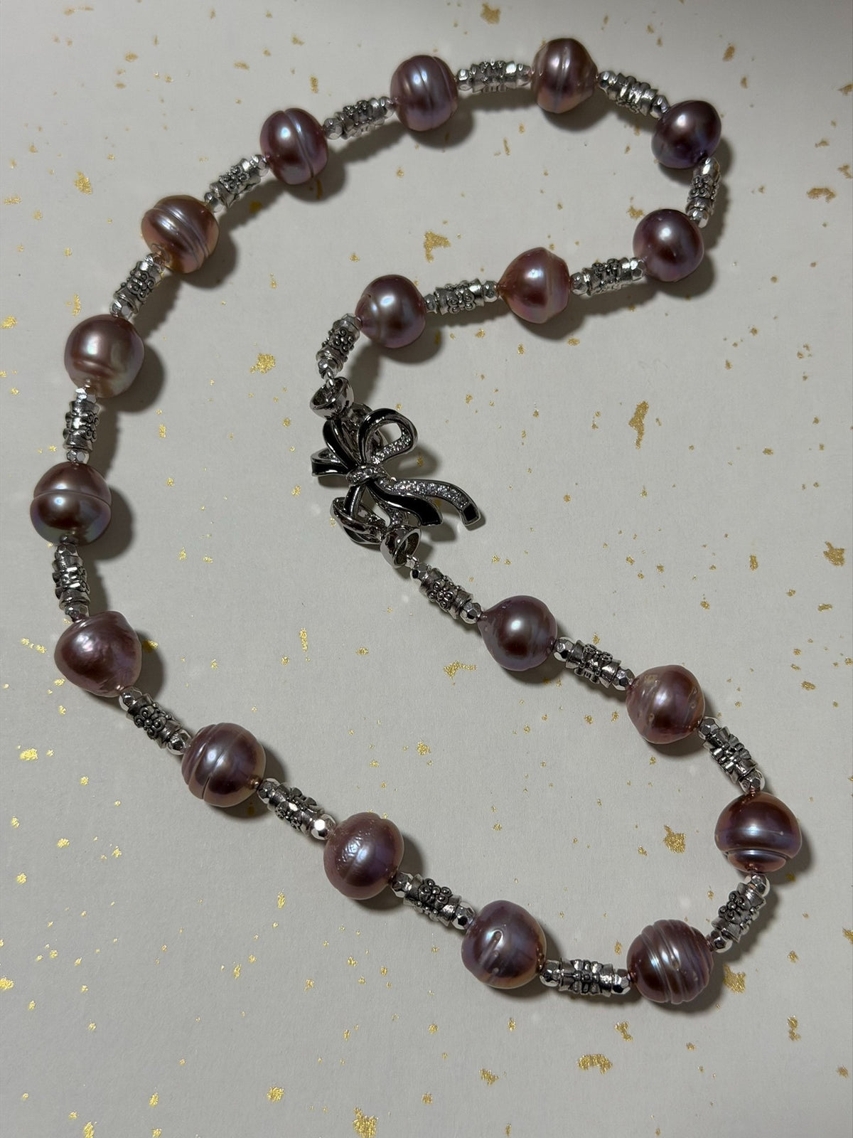 Collier de perles mauve avec fermoir en nœud