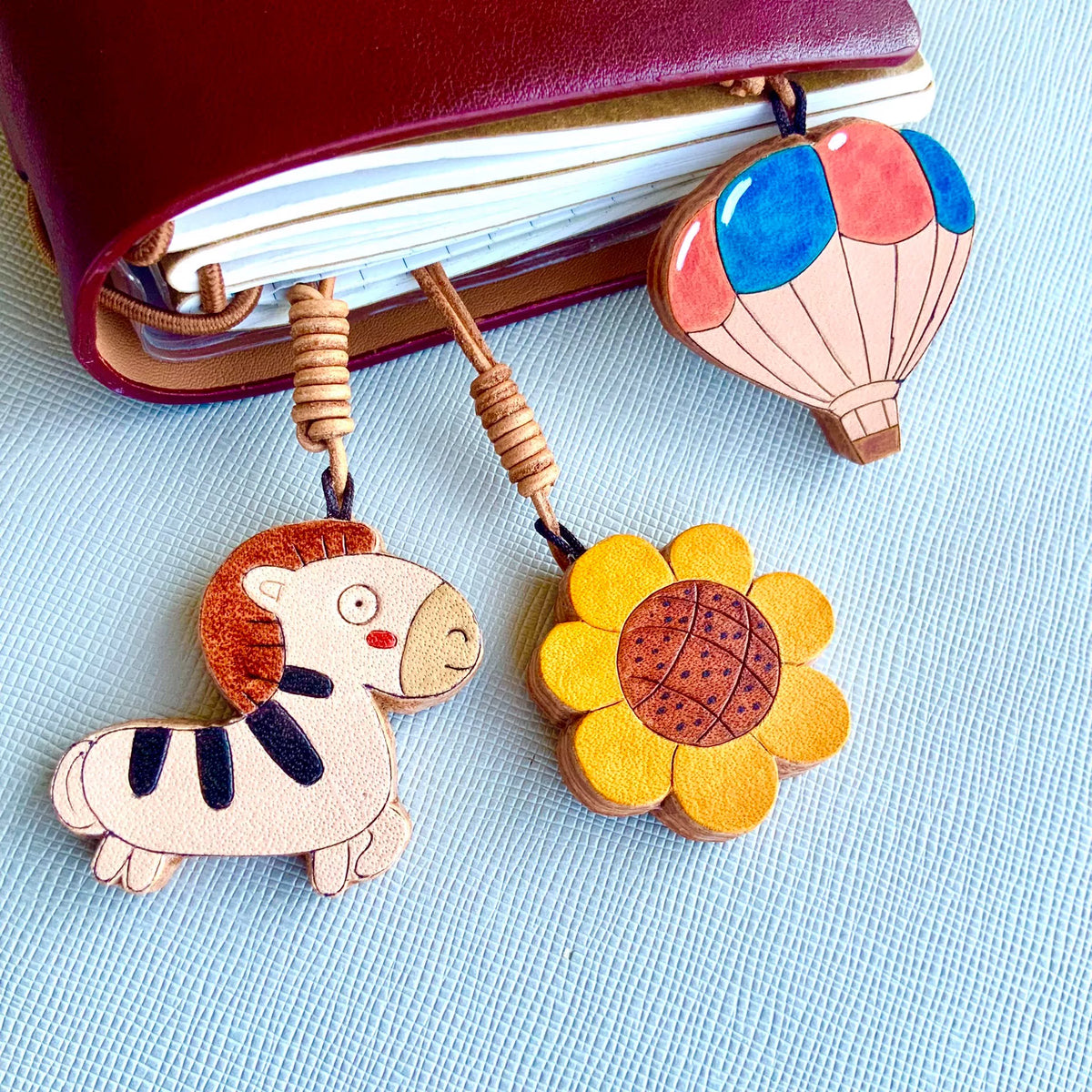 Set de charms de cuero: globo aerostático, cebra y girasol