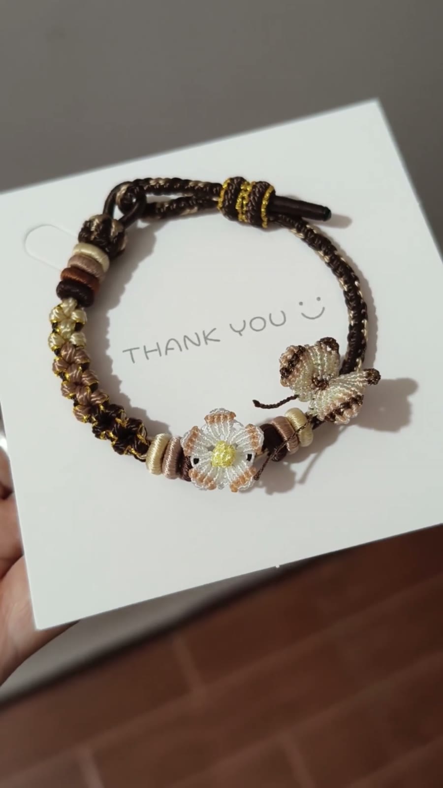 Handflätat armband i snöre svart guld blomma