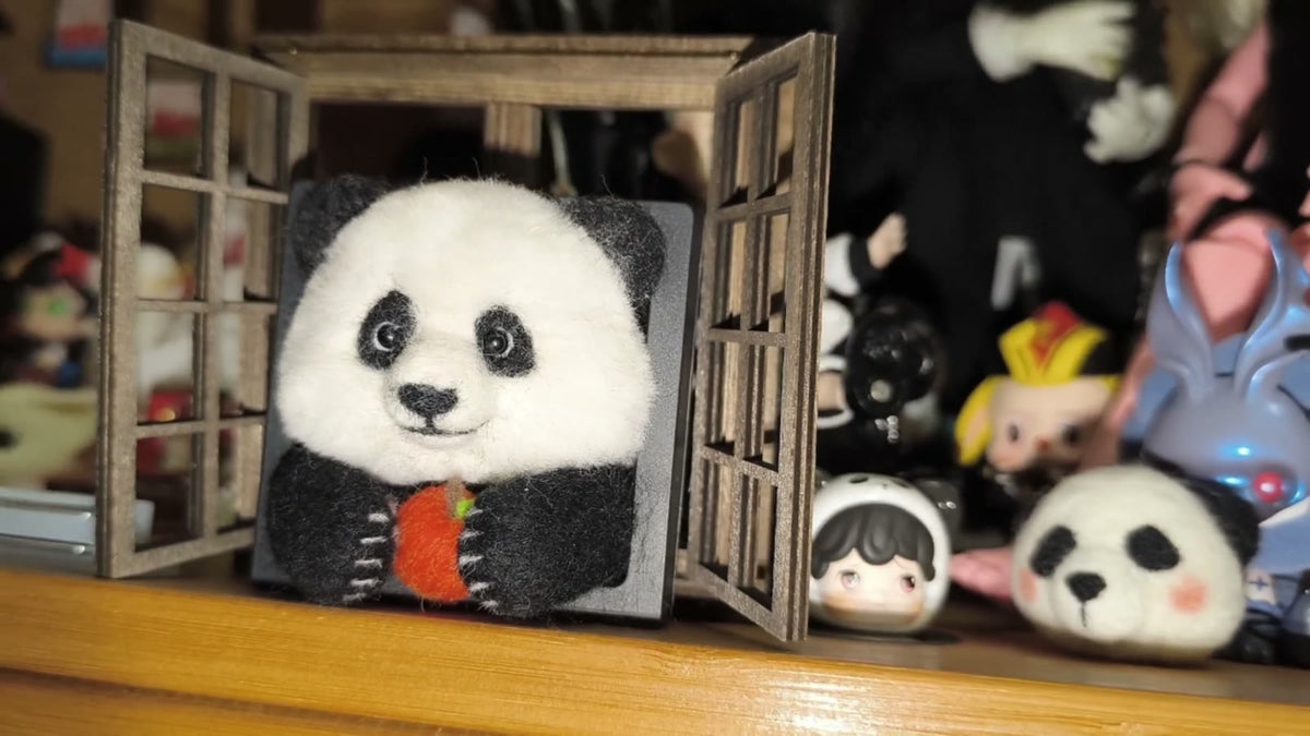 Handgjord ramdekor med panda i ullfilt som äter äpple
