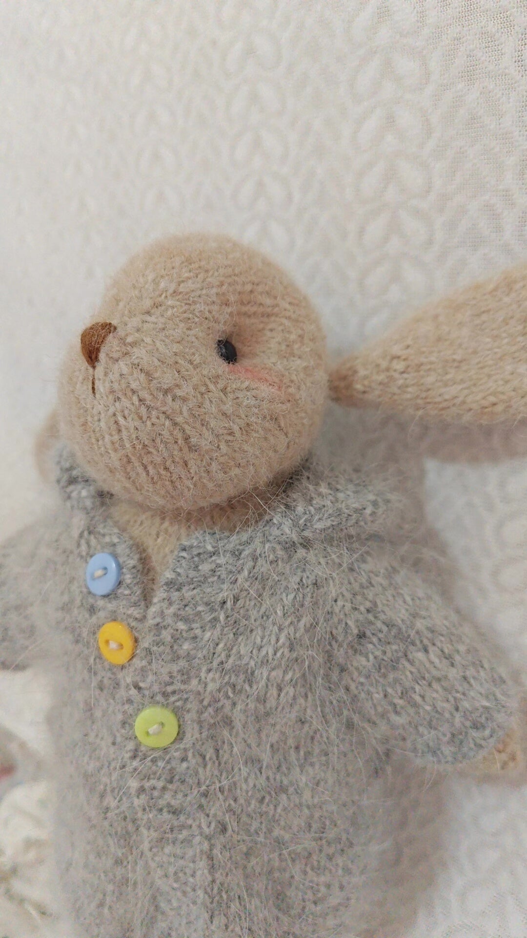 Handgestricktes Hasen-Spielzeug mit grauem Pullover