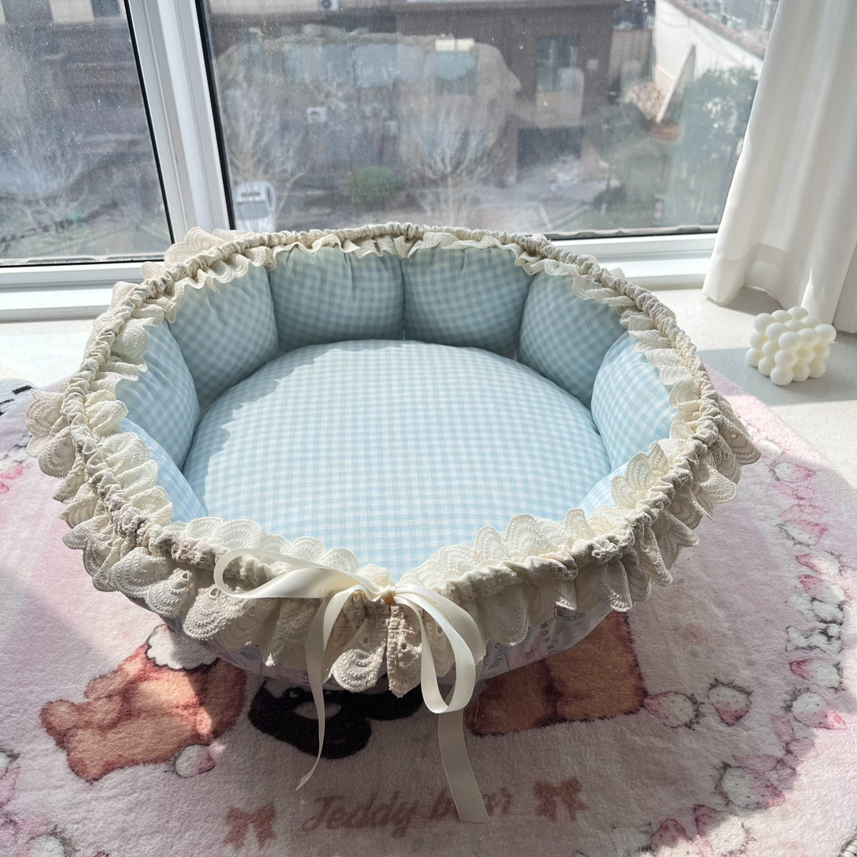 Blå husdjursbädd i lapptäcke med kattmotiv och gingham