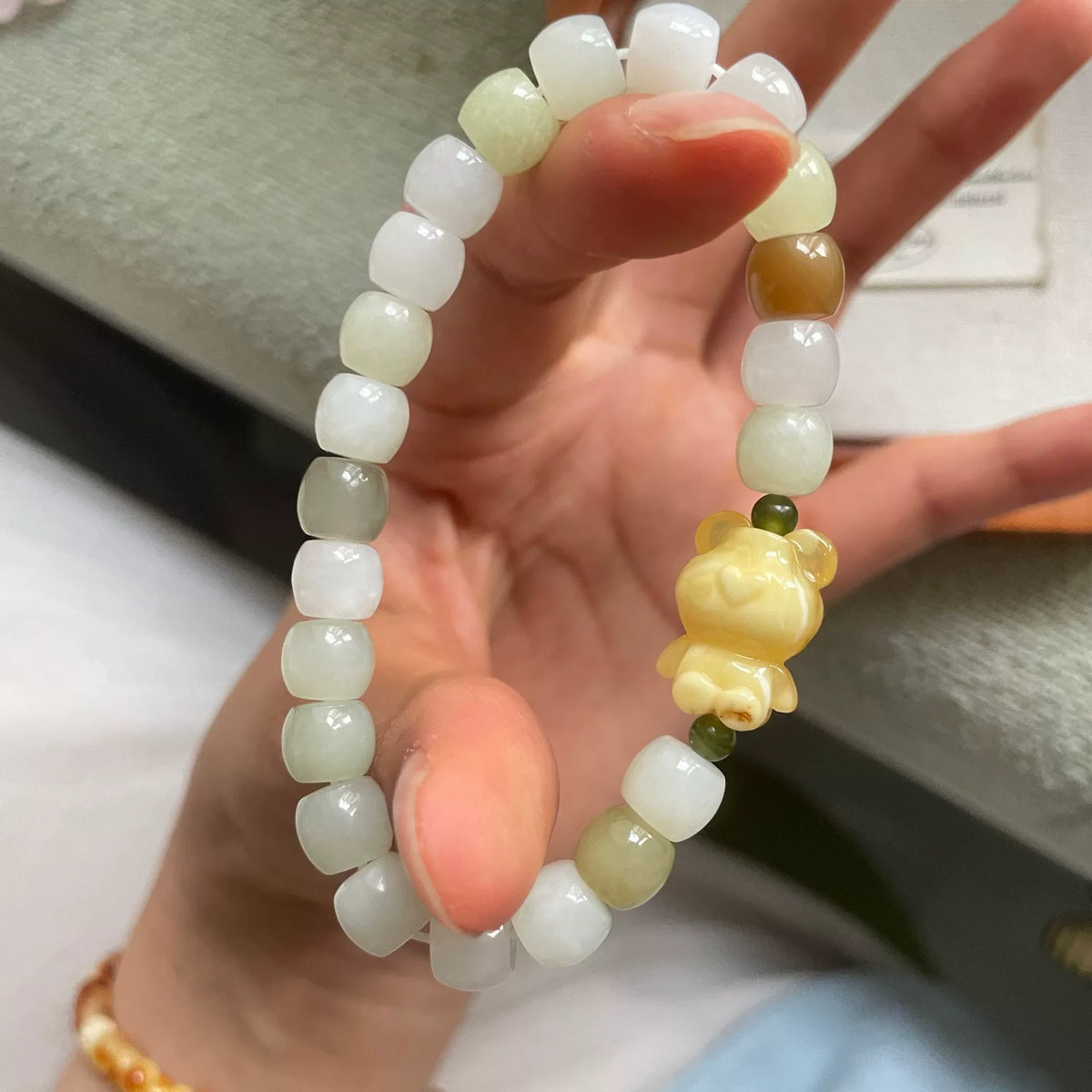 Armband i honungsbärnsten med björn och Hetian-jad