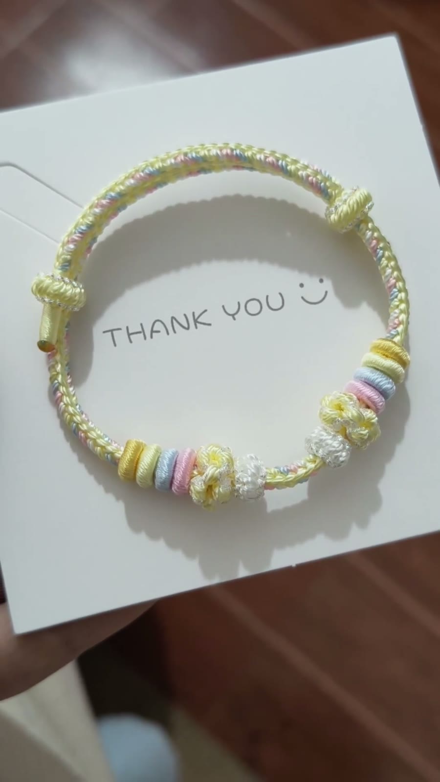 Handgeflochtenes Regenbogen-Kordarmband mit Blumenanhängern