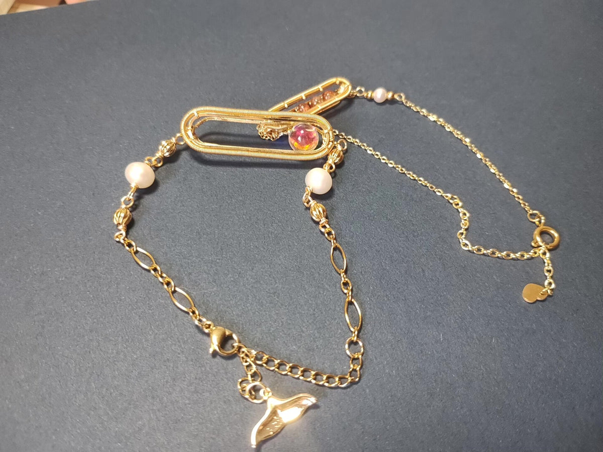 Goudenen armband met zandloper draadwerk en parels