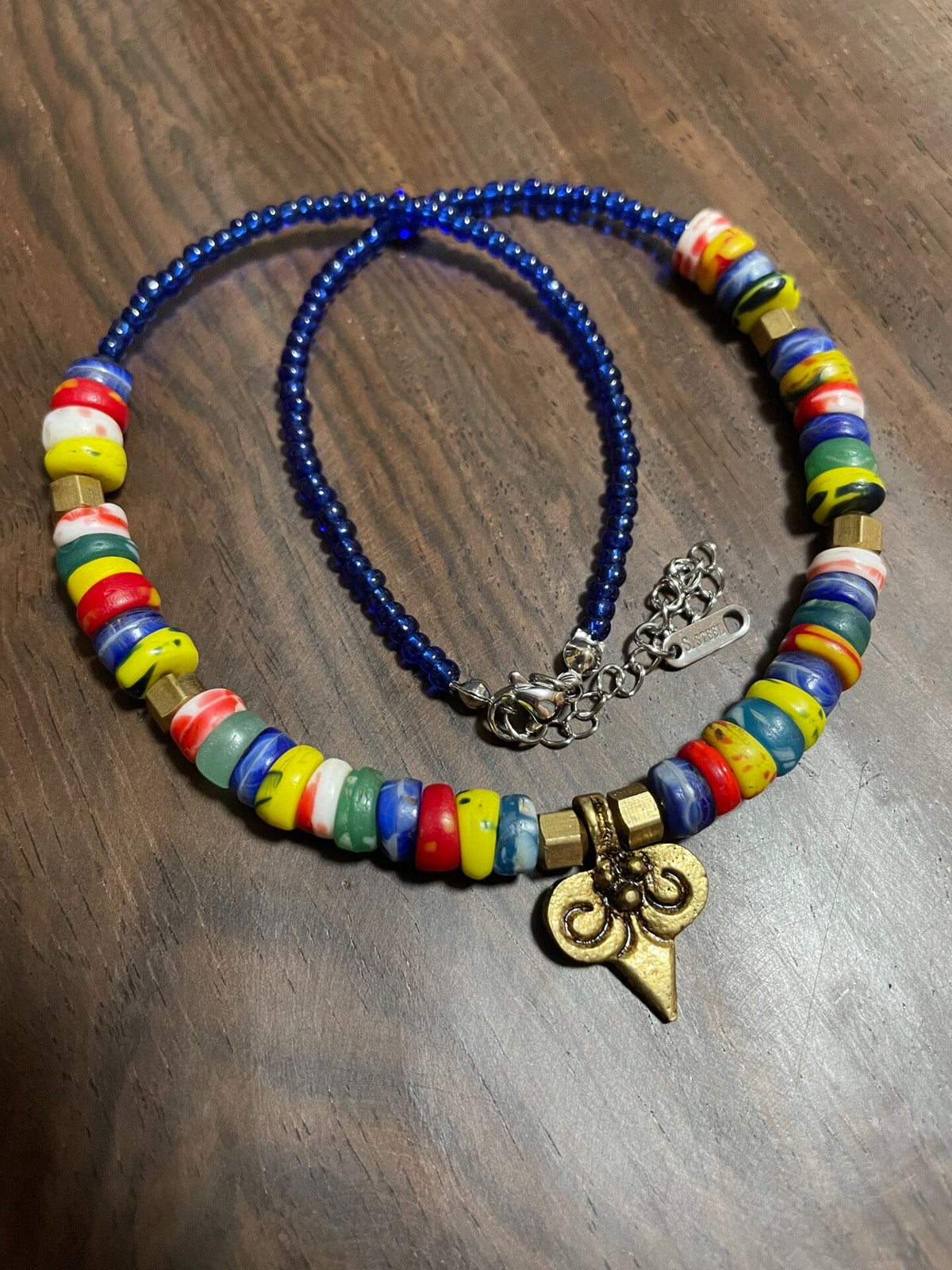 Collier en perles de verre multicolores et pendentif en laiton