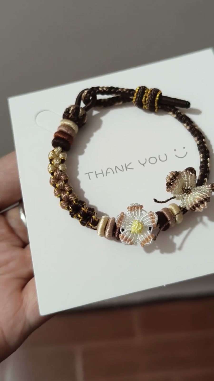 Handflätat armband i snöre svart guld blomma