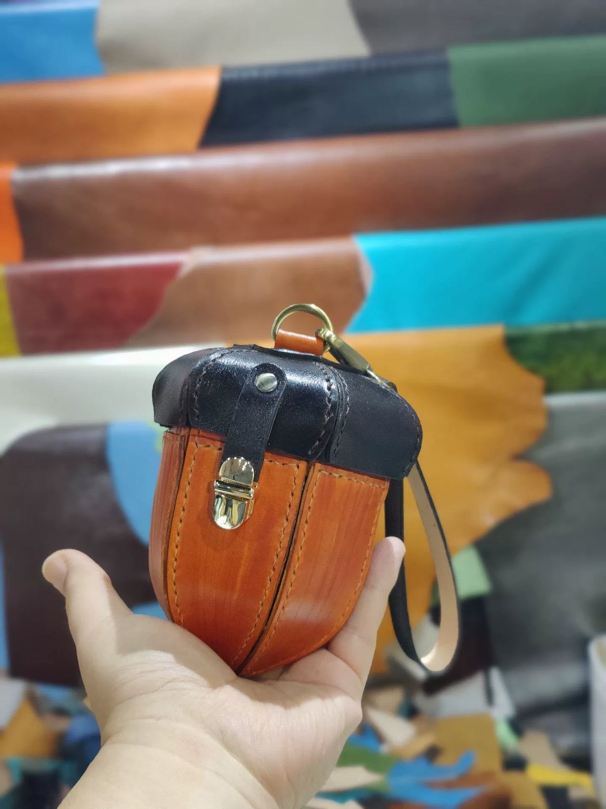 Pochette in pelle bicolore con chiusura in ottone