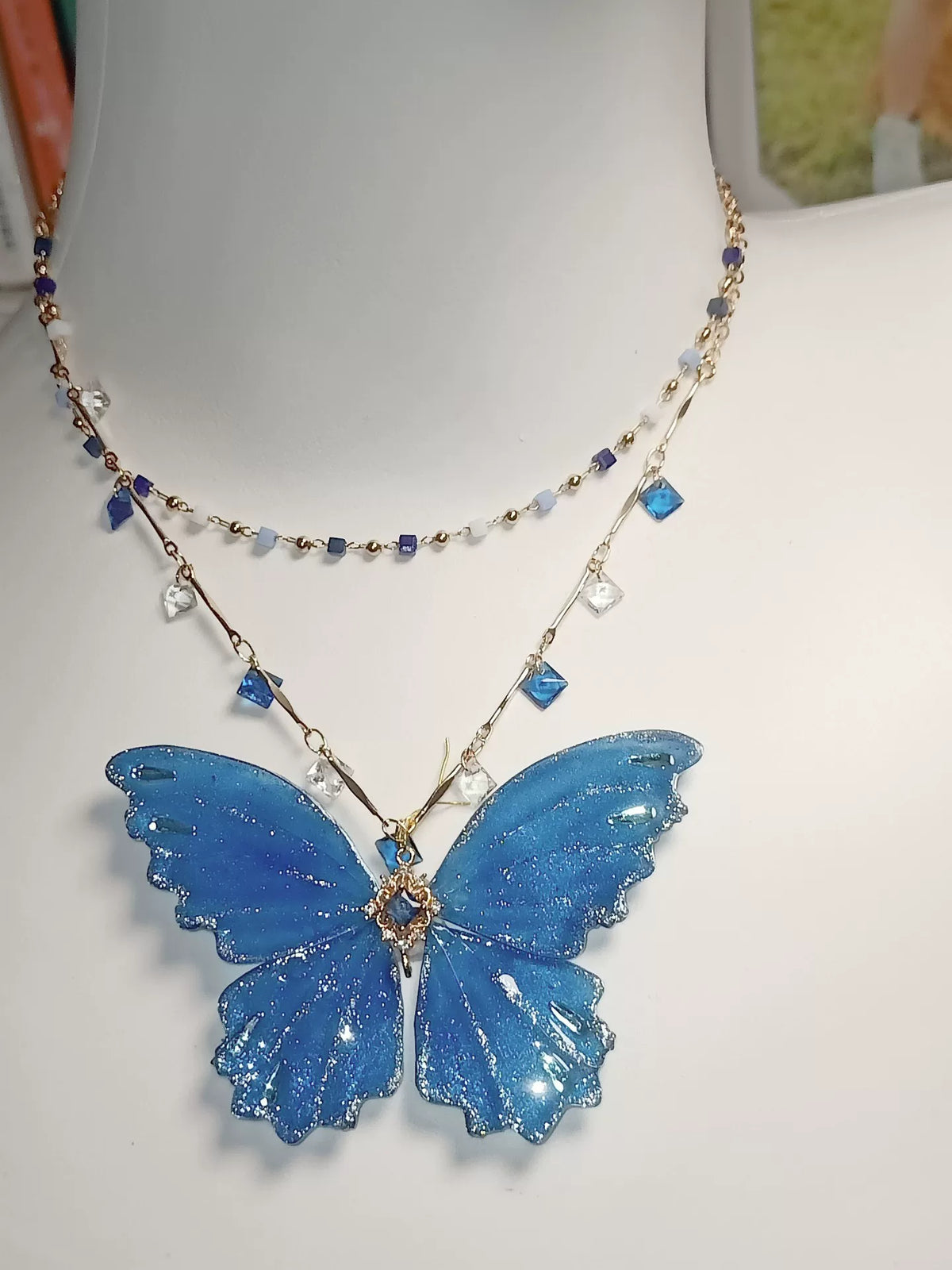 Collar de mariposa en laca azul y purpurina