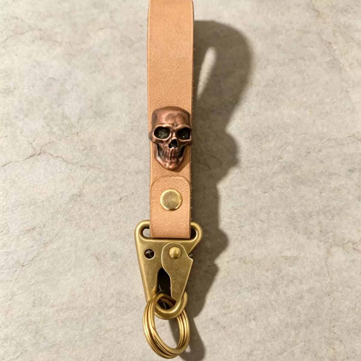 Llavero de cuero curtido vegetalmente hecho a mano con calavera de cobre