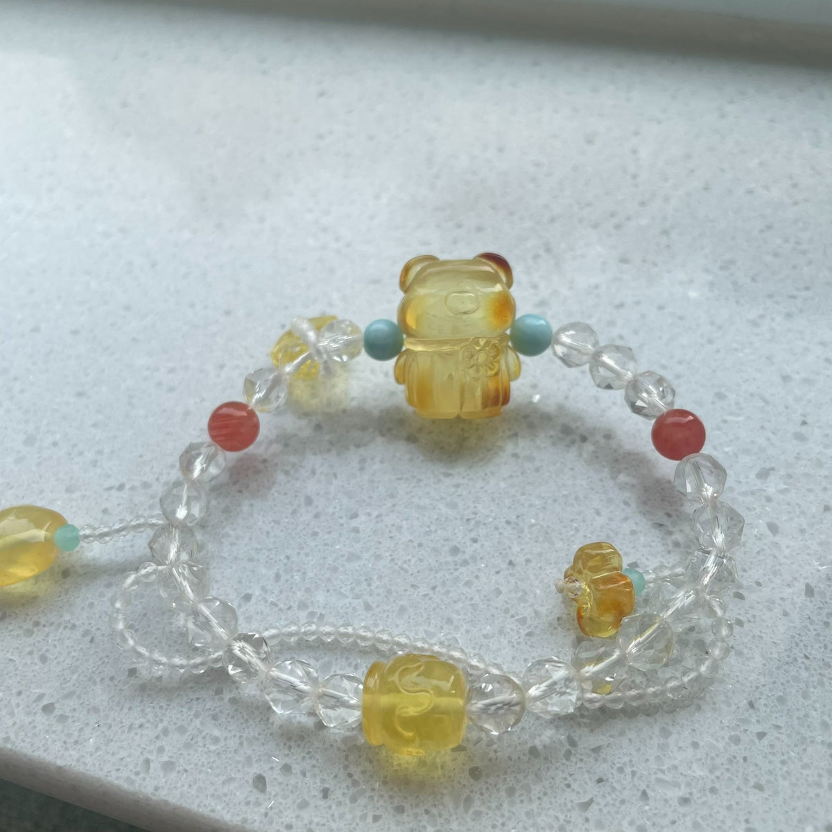Armband med bärnstensbjörn, vit kristall och tofsar