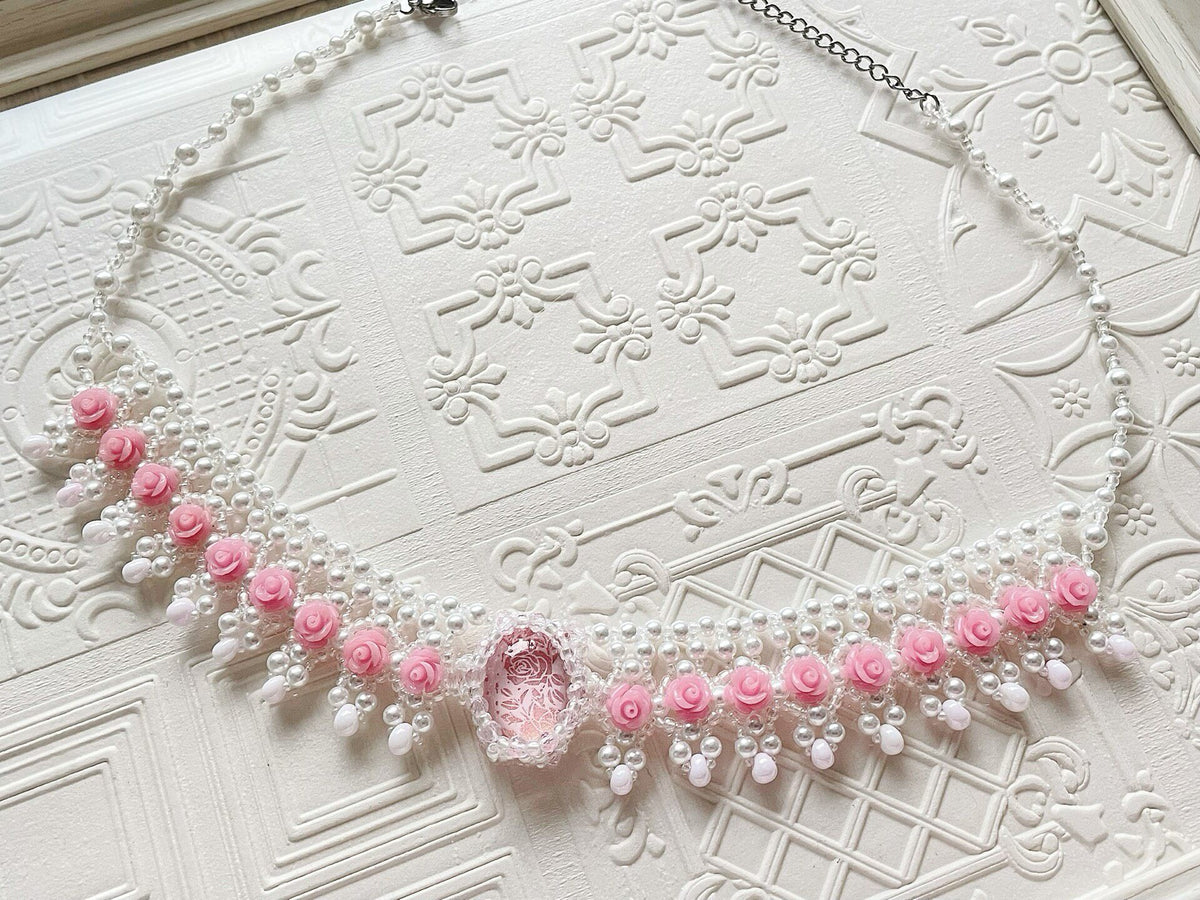 Roze kralenketting met rozenbloemen