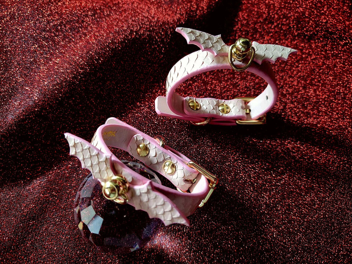 Coppia di braccialetti rosa con scame di serpente e ali