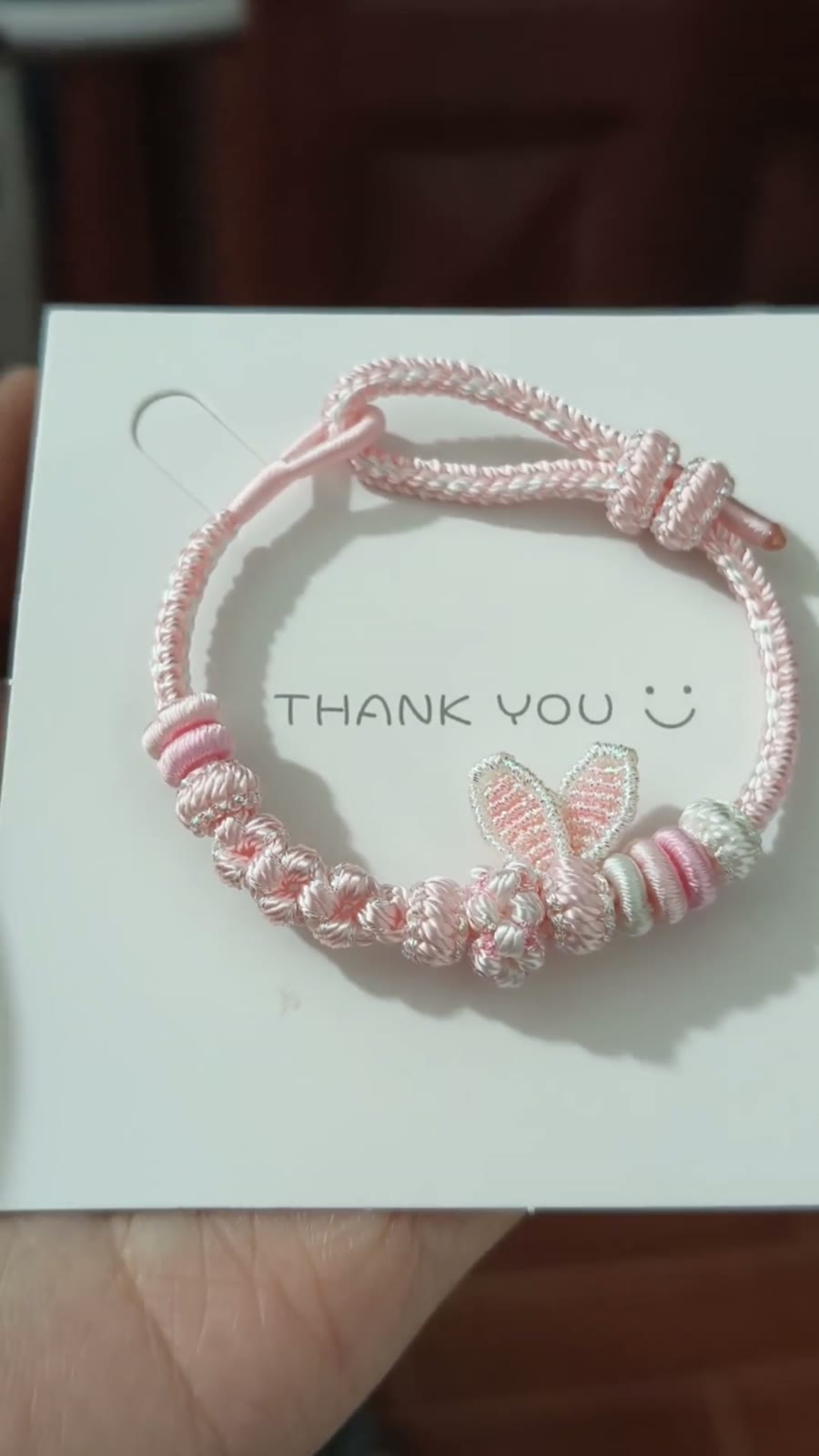 Handgema roze gevlochten armband met konijnenostjes