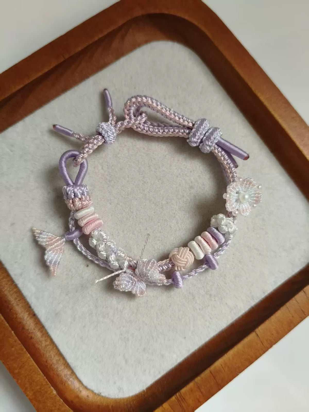 Pulseira tecida à mão com gradiente rosa e branco e charms de borboleta