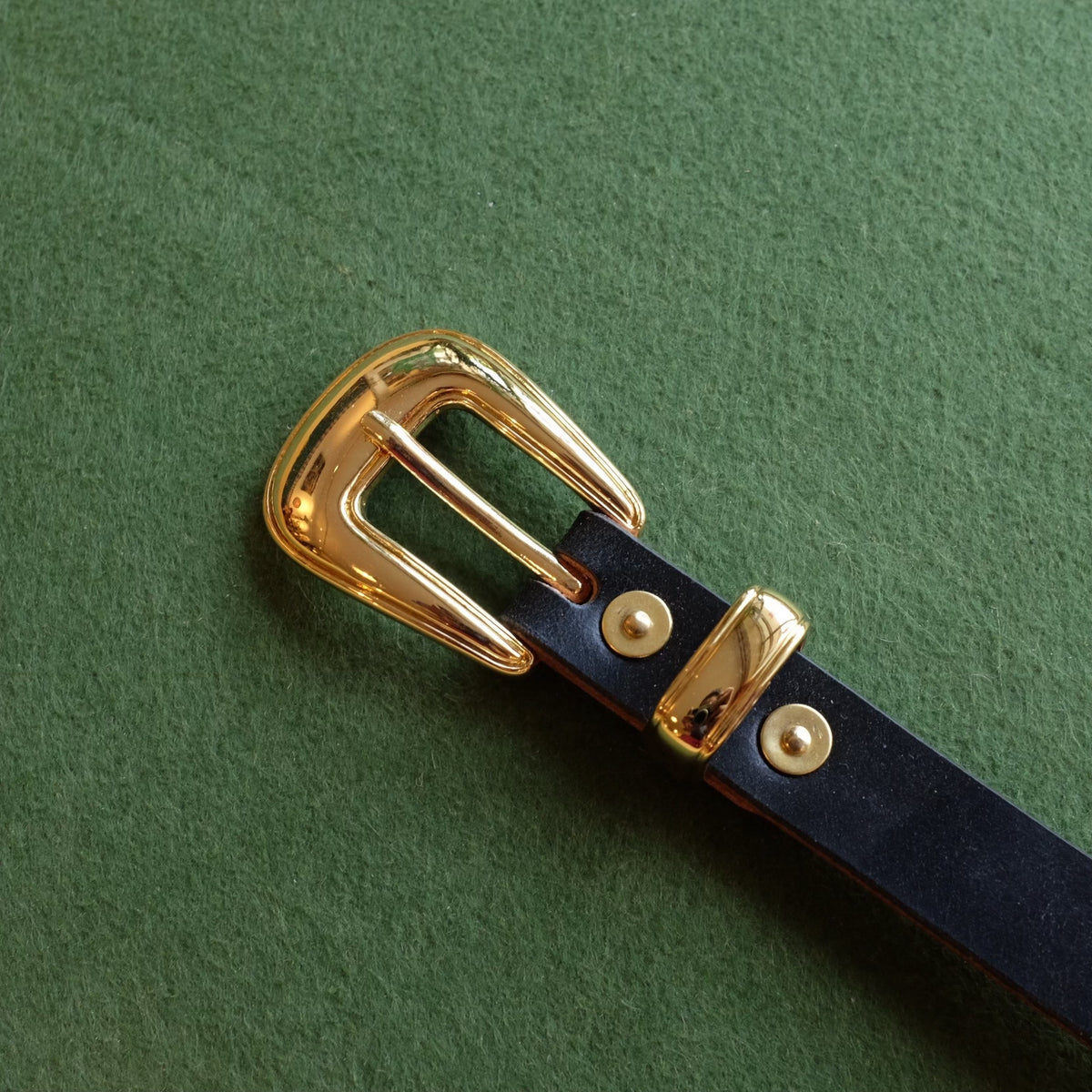 Svart läderbälte i bridle med guldspänne