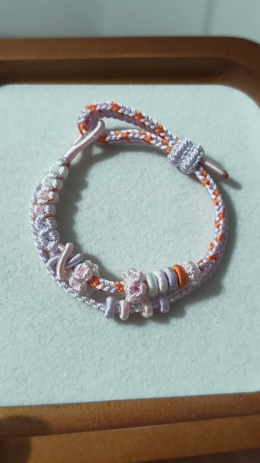 Handvävt armband i snöre vit och orange blomma