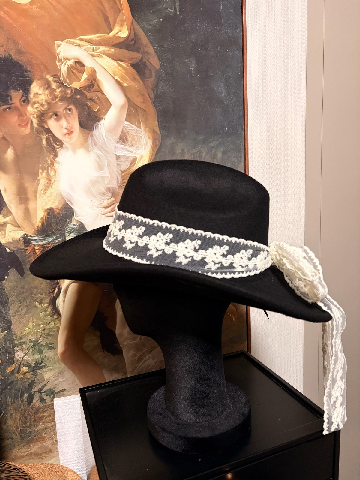 Cappello nero a tesa larga con fiocco in pizzo bianco