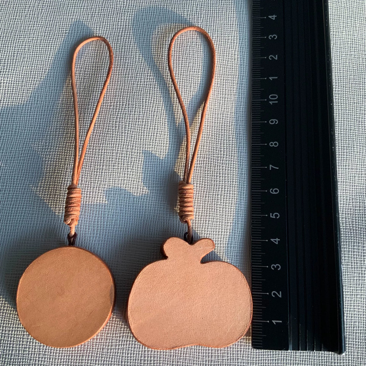 Handgesneden leren charms met zon en appel