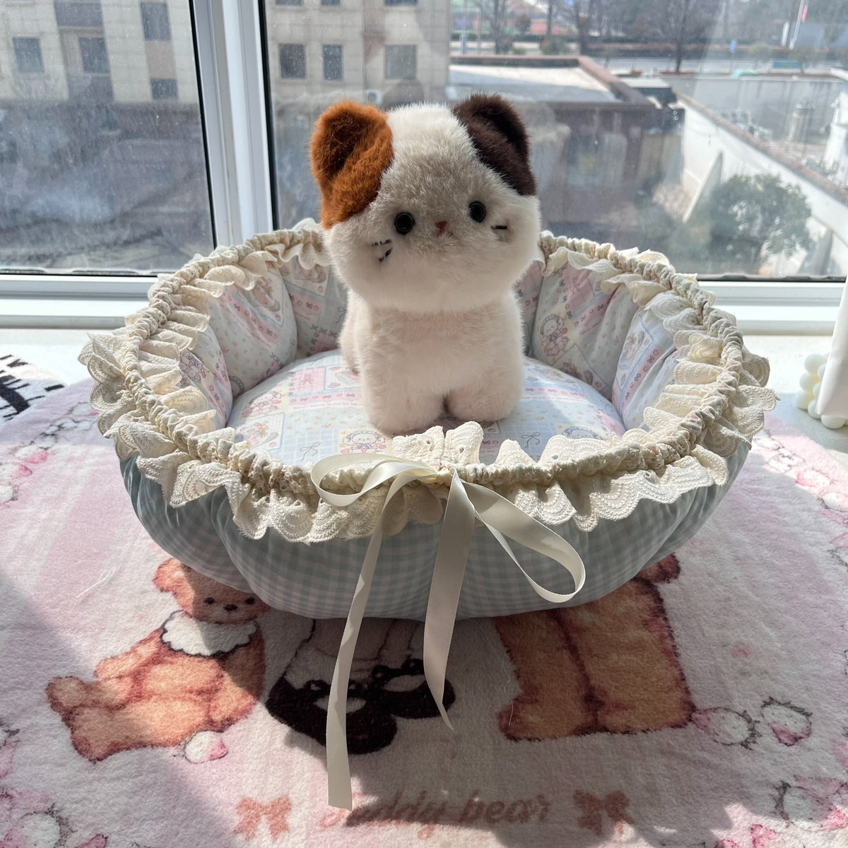 Blå husdjursbädd i lapptäcke med kattmotiv och gingham