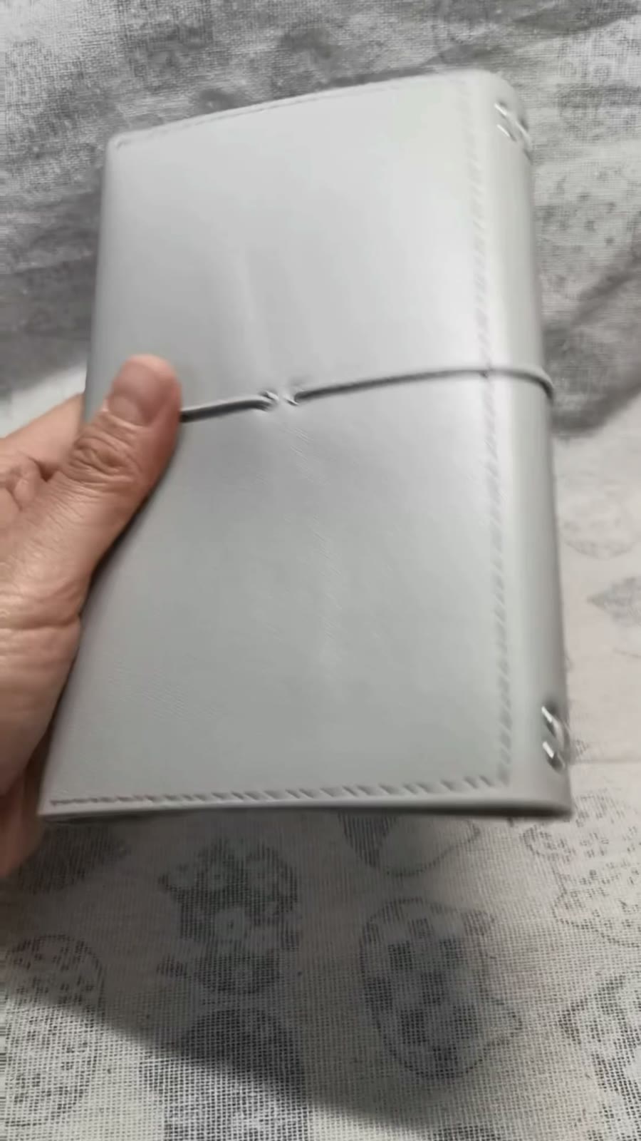 Ljusgrått omslag i läder för resedningsbok, tredelat