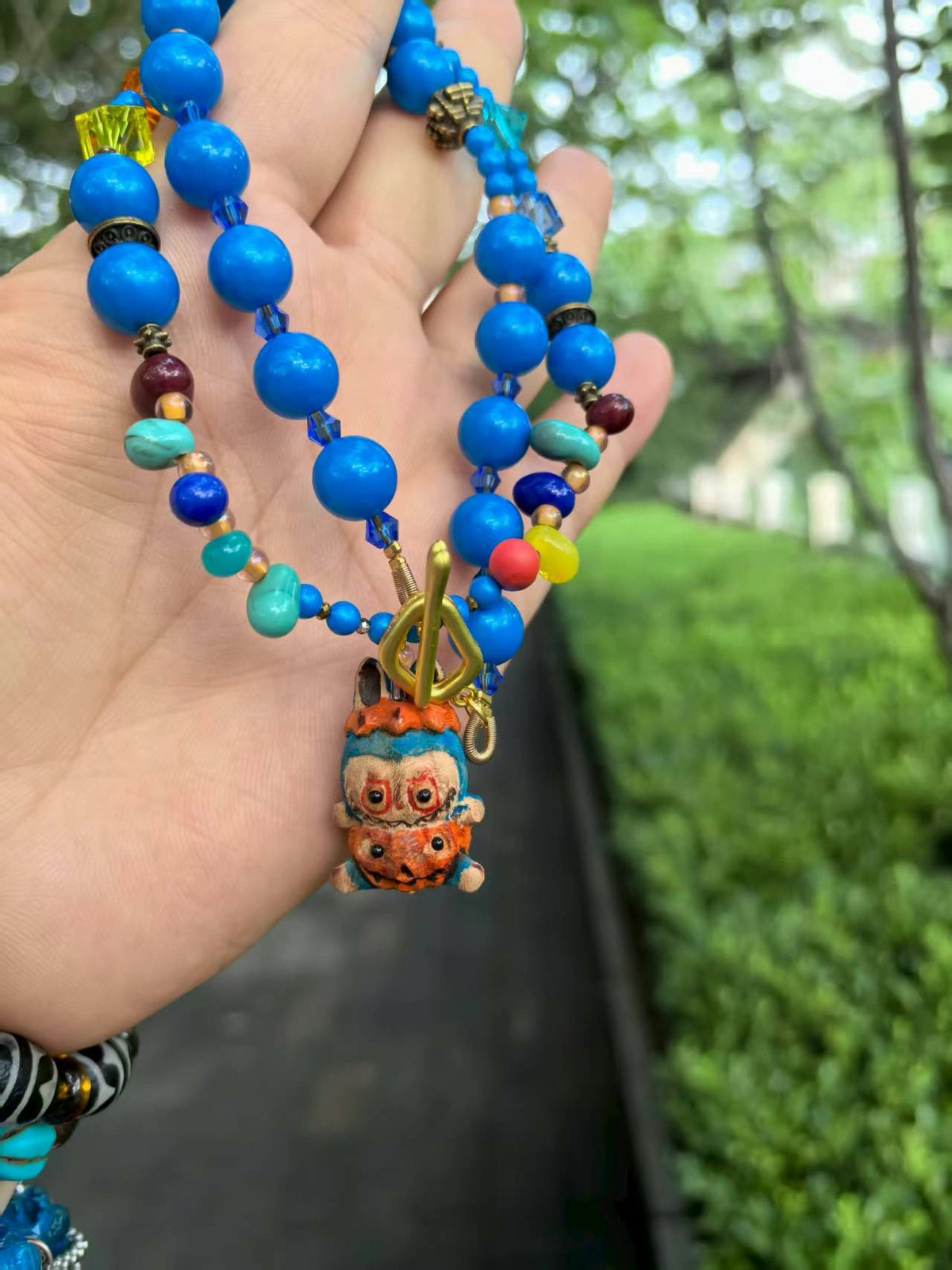 Collana di perle in vetro liuli blu con ciondolo a personaggio
