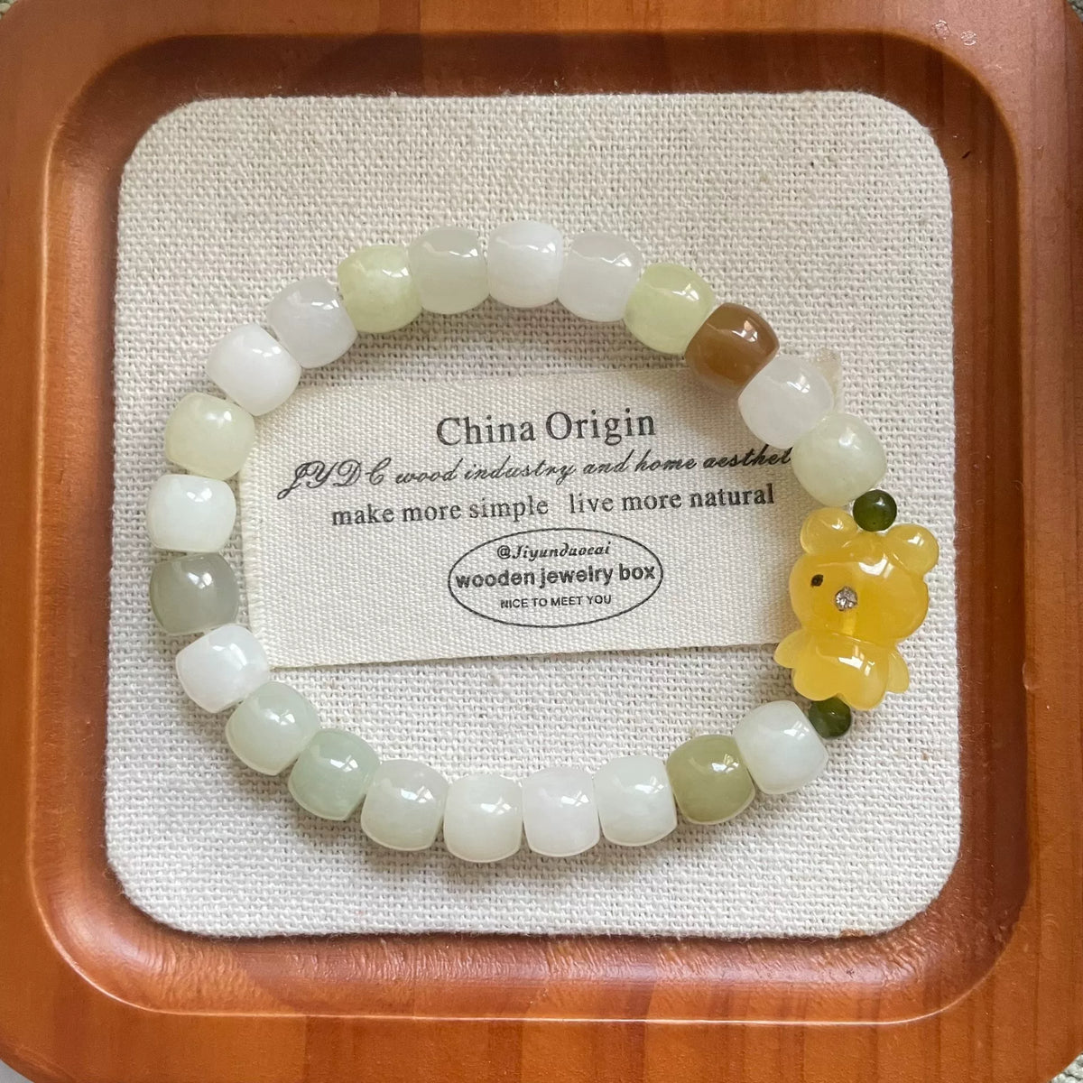 Armband i honungsbärnsten med björn och Hetian-jad