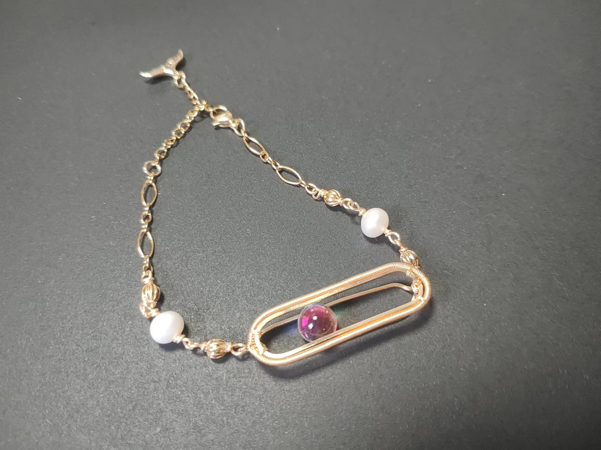 Goudenen armband met zandloper draadwerk en parels