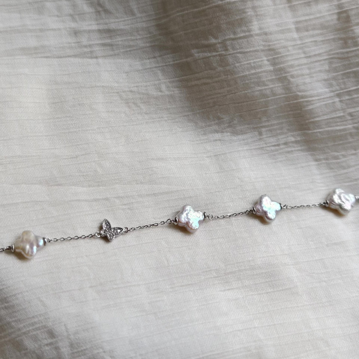 Braccialetto con perle d'acqua dolce e charm farfalla in argento