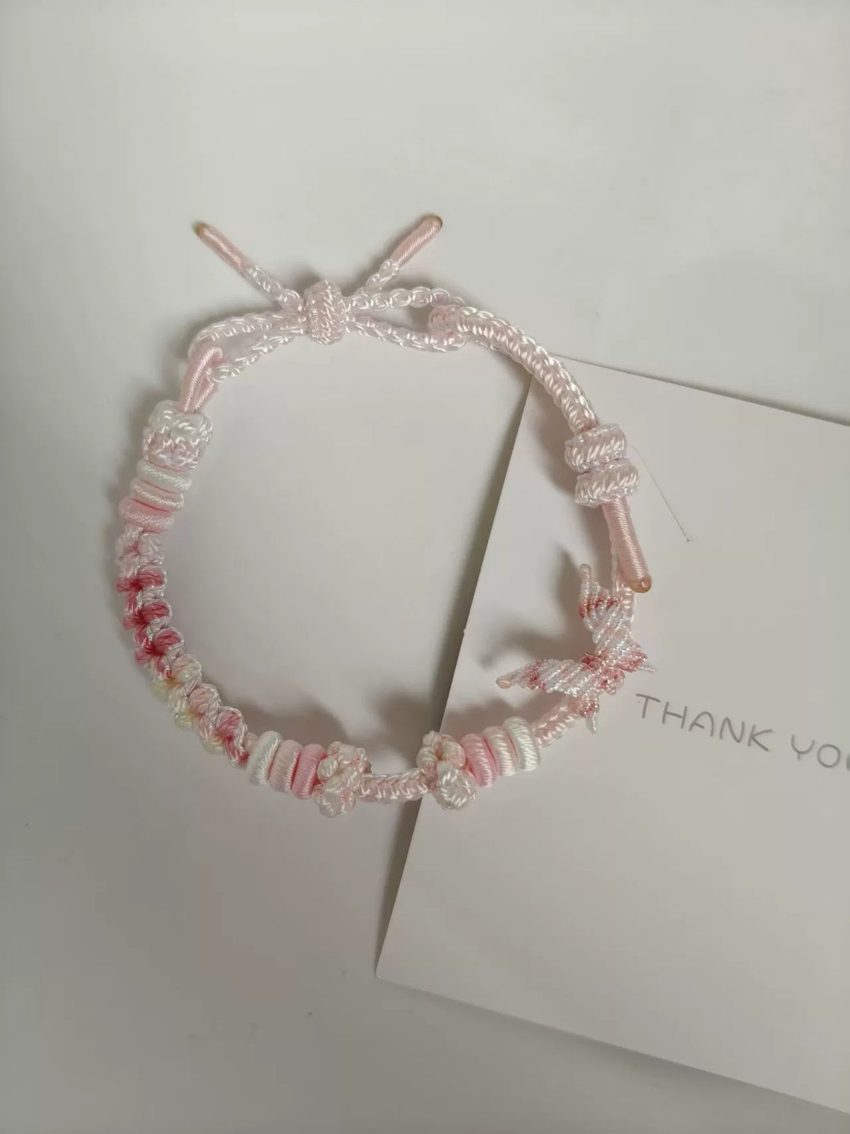 Pulseira Tecida à Mano em Gradiente Rosa e Branco com Pingente de Flor