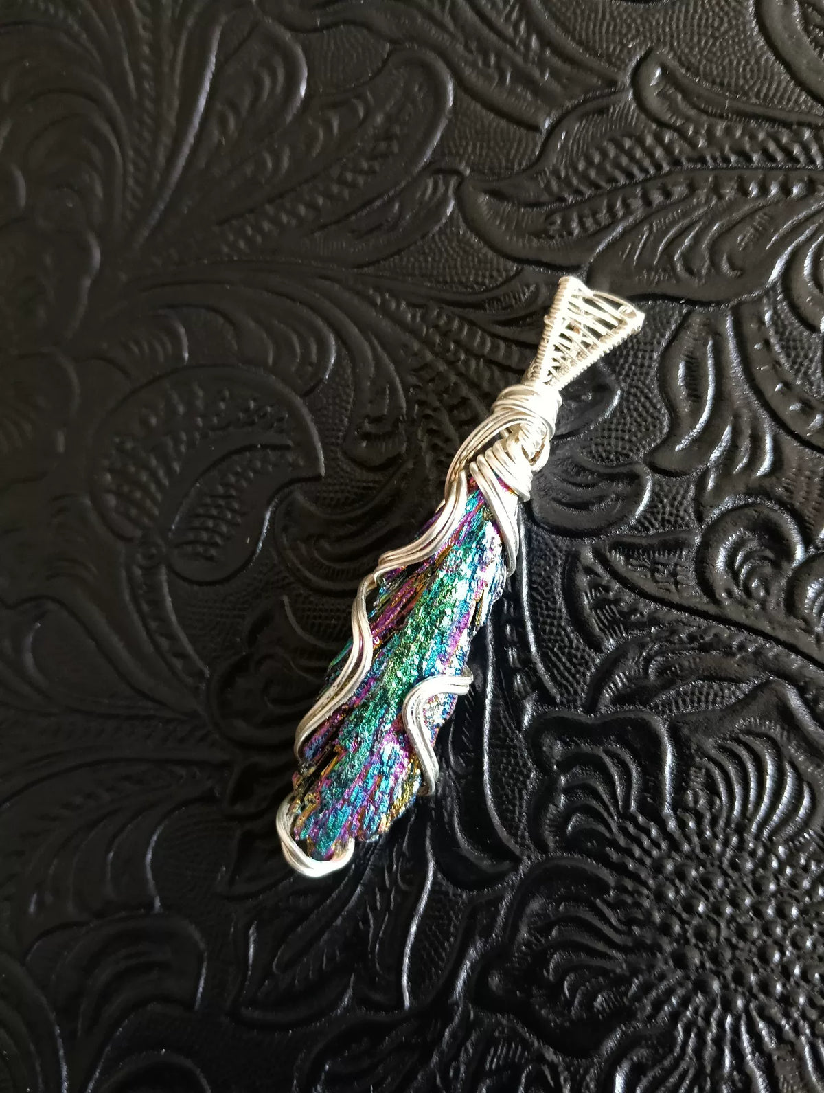Pendente artesanal de mineral iridescente envolto em fio de cobre